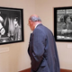A visitor to Los Angeles' National Center For Sitcom Reparations solemnly observes photographs in the museum's Hall Of Atrocities.